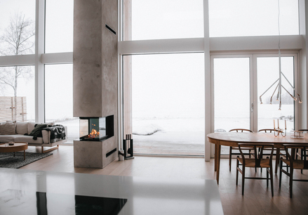 VISIO 3:1 Raumteiler Holz-Kamineinsatz VISIO 3:1 trennt als Raumteiler Esszimmer und Wohnzimmer in einem modernen Haus im Norden